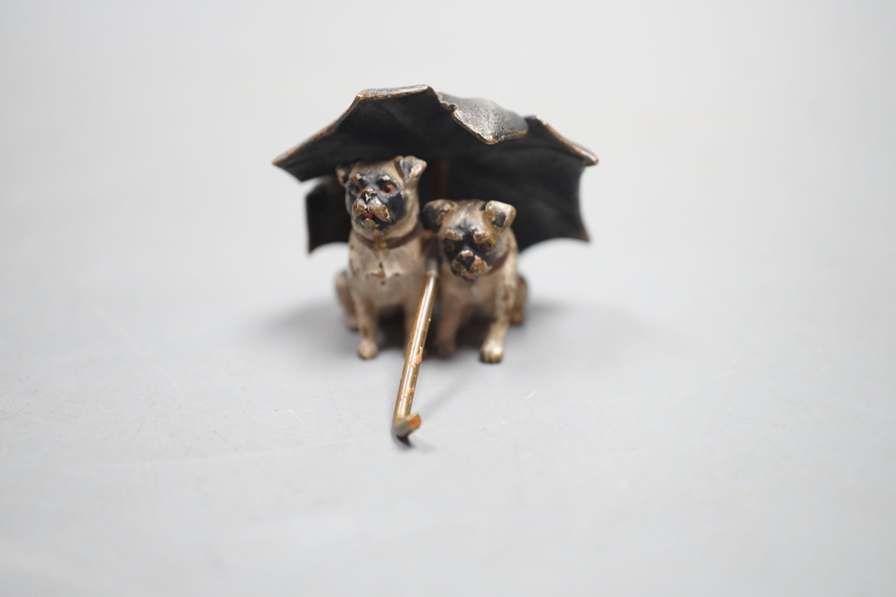 A small Austrian cold painted bronze group of two pug dogs under a rugged umbrella, 3cm